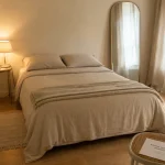 Home staging chambre : chambre lumineuse et dégagée, lit et miroir